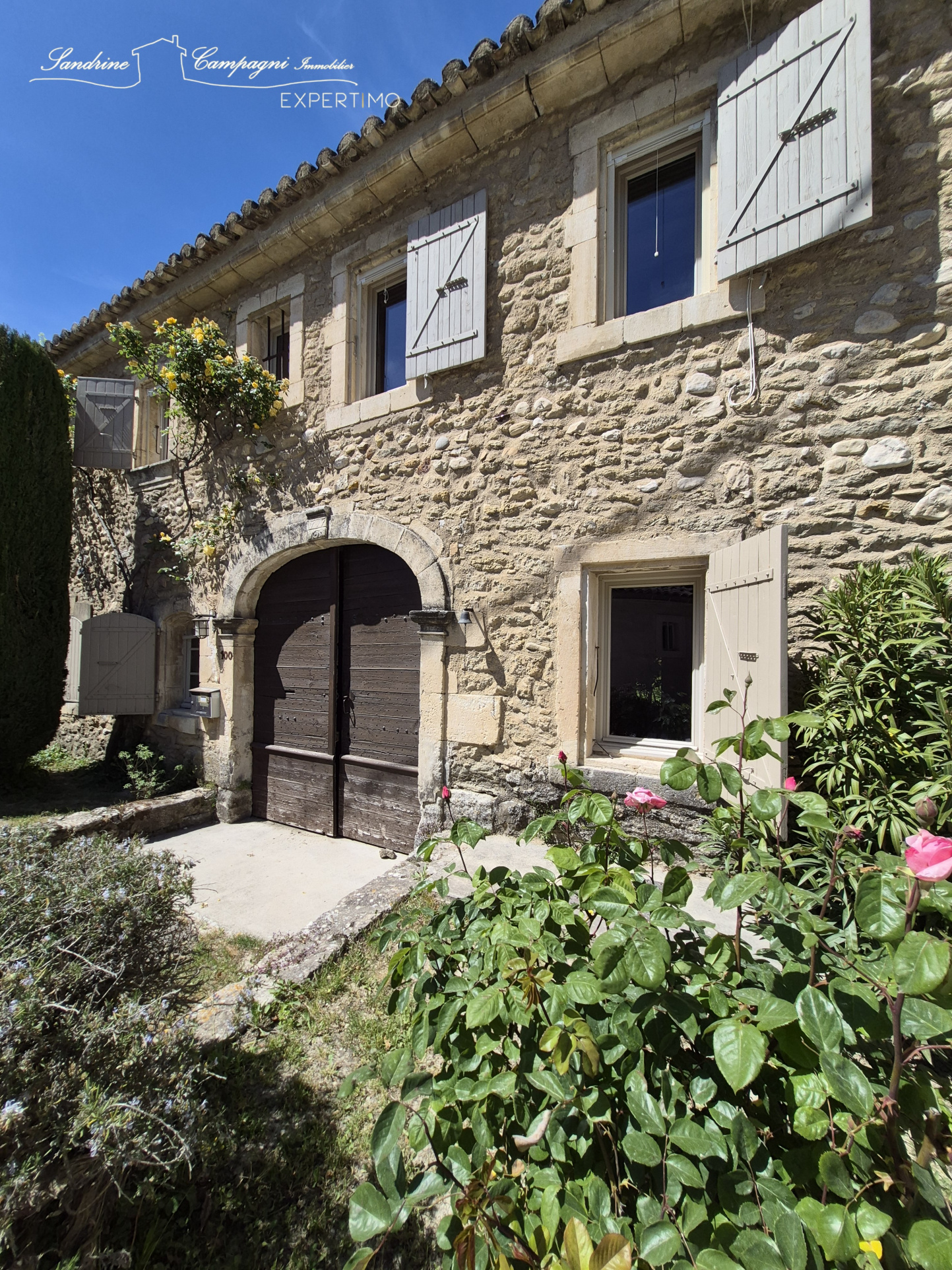 Stone farmhouse in Maubec Facade of a stone farmhouse with wooden shutters, surrounded by greenery in Maubec.