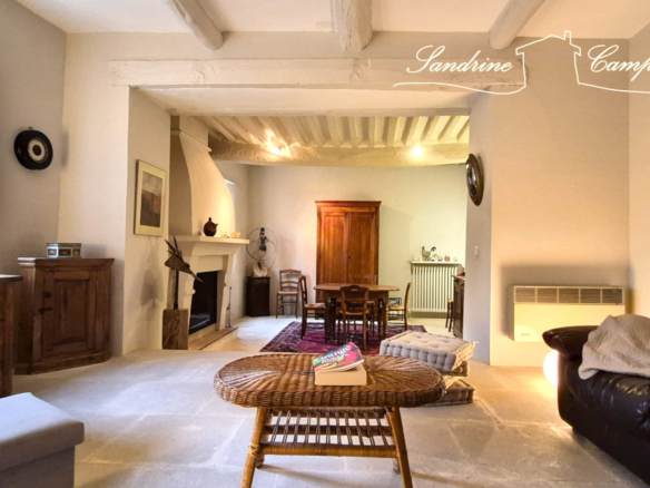 Interior of a restored farmhouse with living room, fireplace and wooden furniture.