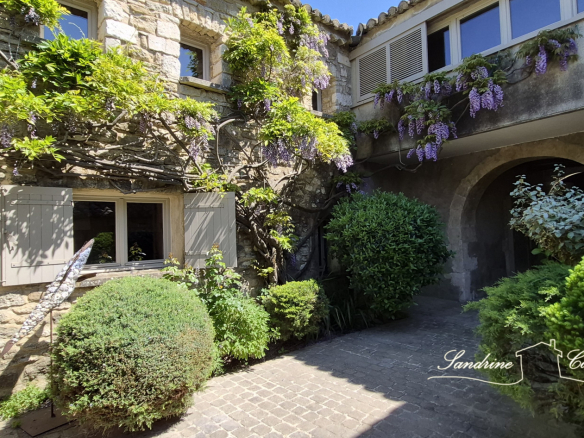 Entrance to an old farmhouse with climbing plants and landscaping.