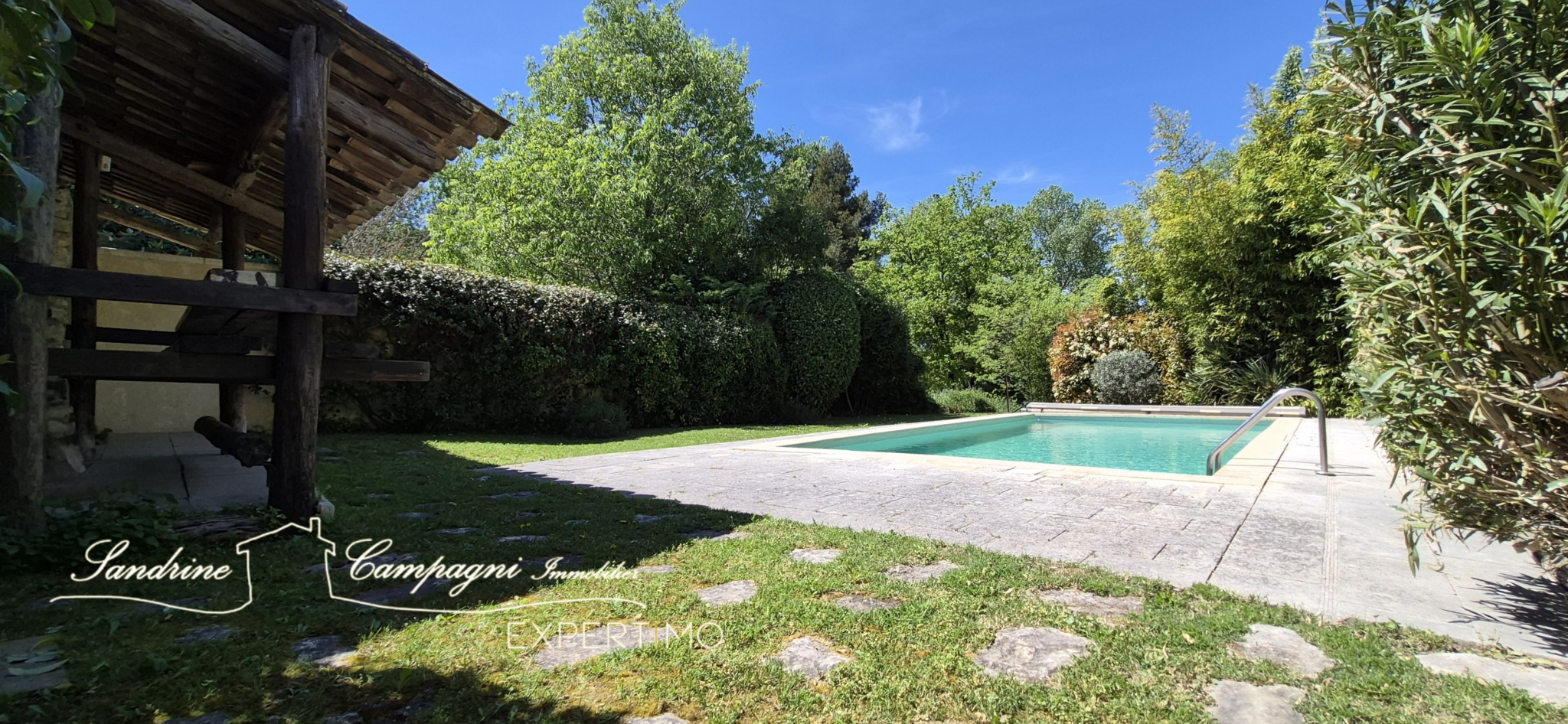 Farmhouse with swimming pool in Maubec Swimming pool and landscaped area around an old farmhouse in Maubec, with lawn and trees.