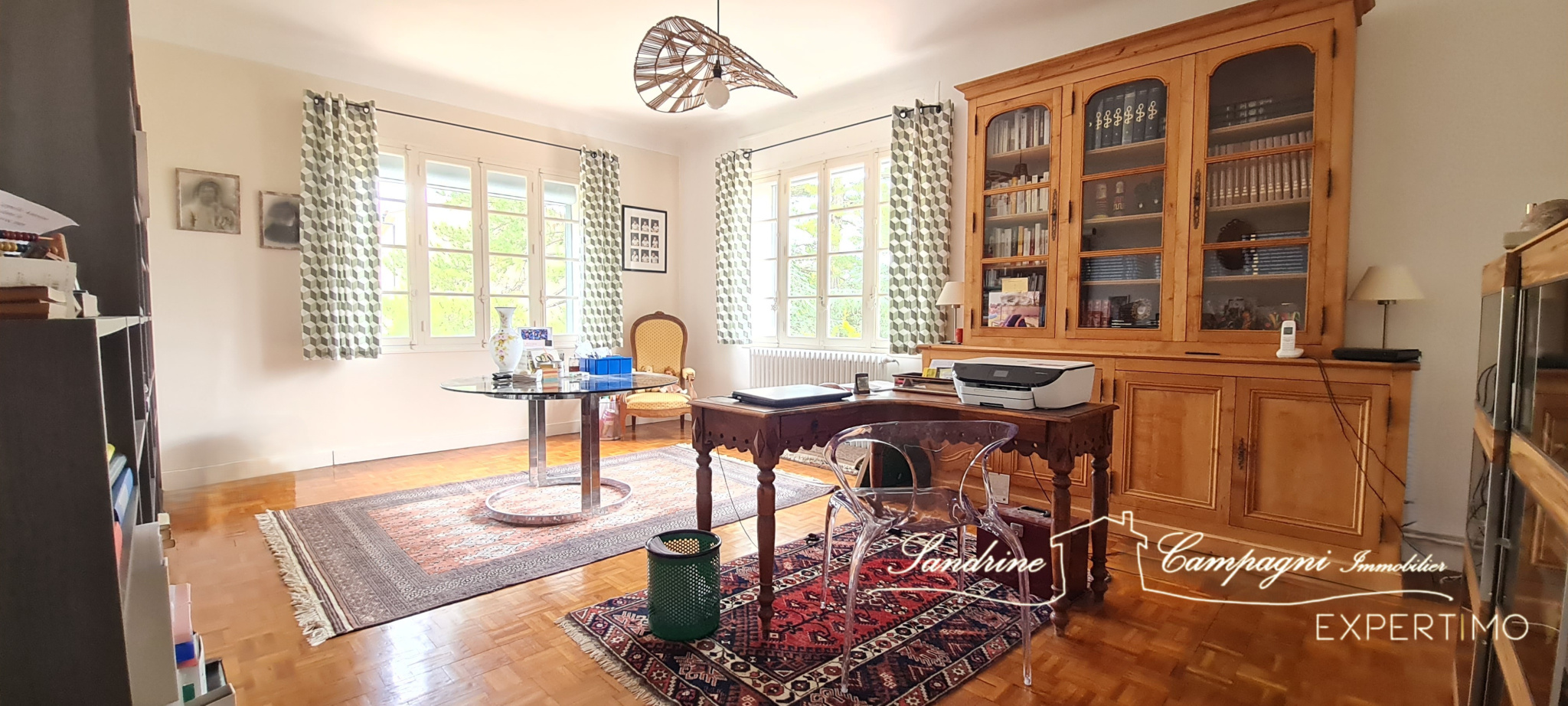 Interior of a renovated house in Mazan Interior of a renovated house with an office and a library, windows offering a view of the garden.