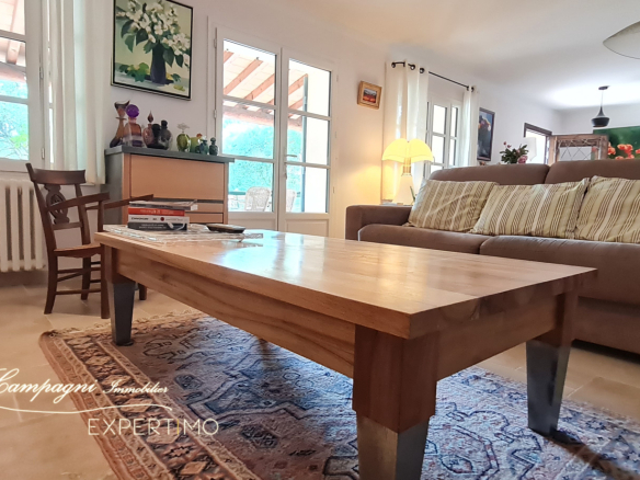 Interior of a renovated house with living room, wooden coffee table and sofa, natural lighting.