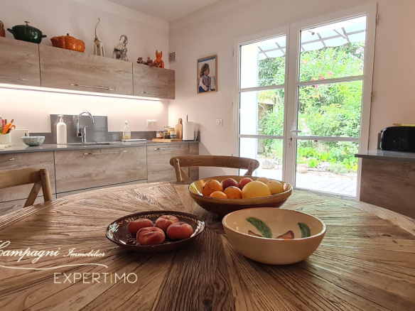Interior of a modern kitchen with a wooden table and fruit, natural light