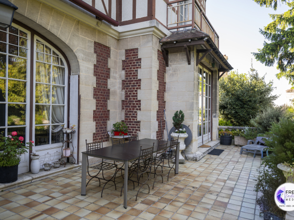 Terrace of a bourgeois house in Noyon with garden furniture and plants.
