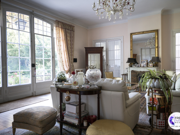 Interior of a bourgeois house with a bright living room, windows and elegant furniture.