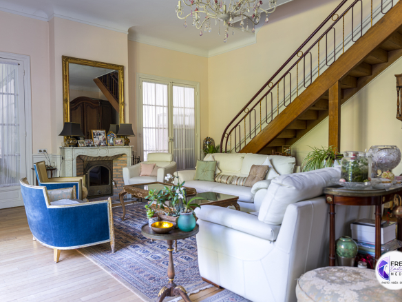 Interior of a bourgeois house in Noyon with living room and wooden staircase.