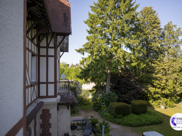 View of a wooded garden with a bourgeois house in Noyon, Oise.