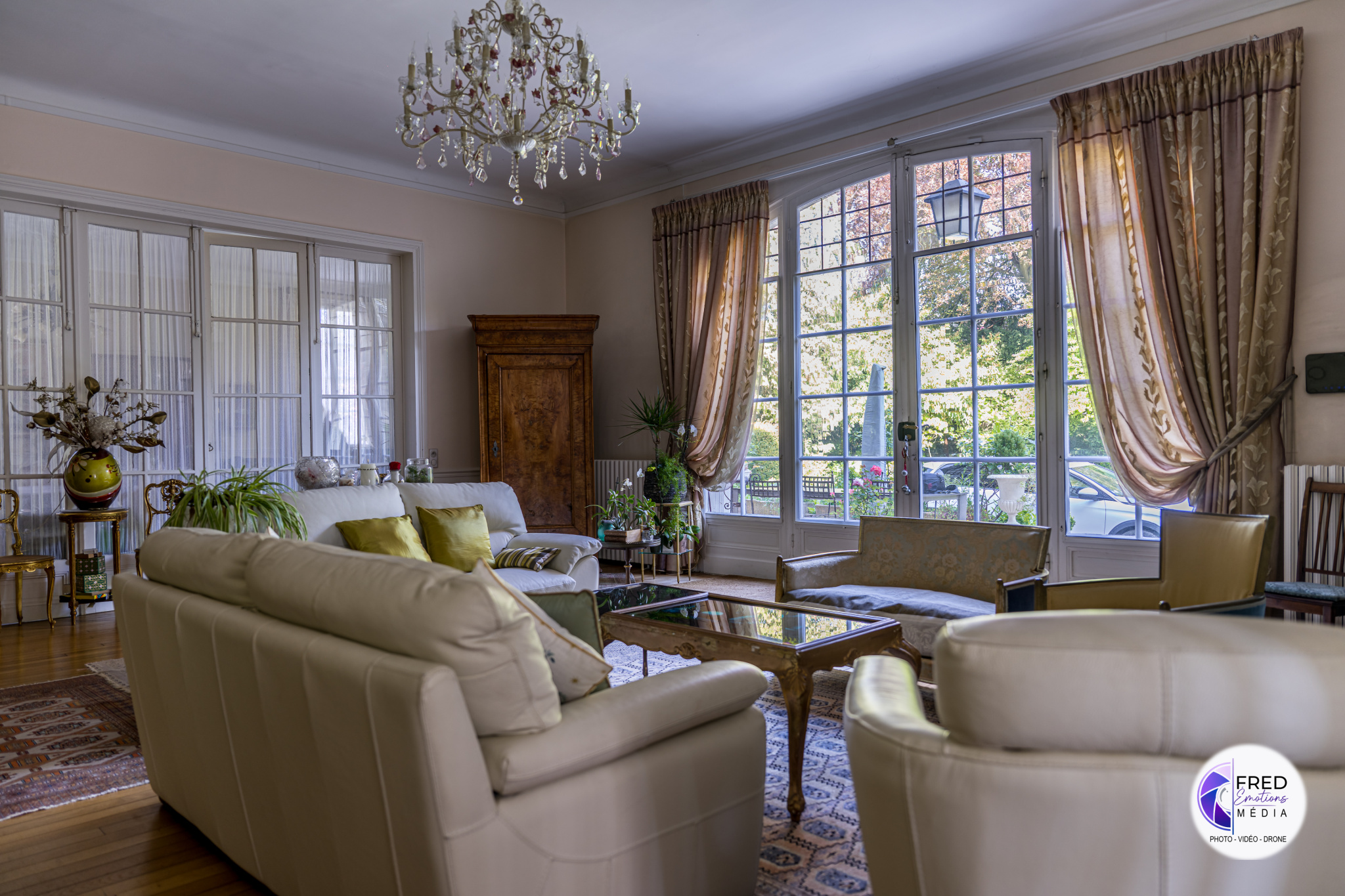 Living room of a bourgeois house in Noyon Interior of a bright living room with light-colored sofas and large windows.