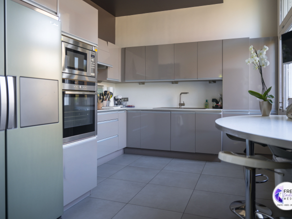 Modern kitchen with wooden furniture and integrated appliances.