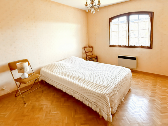 Room in a family property in Tourrettes-sur-Loup with a wooden bed and chair.