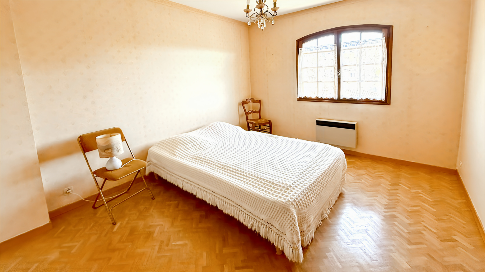Room in a family property in Tourrettes-sur-Loup with a wooden bed and chair.