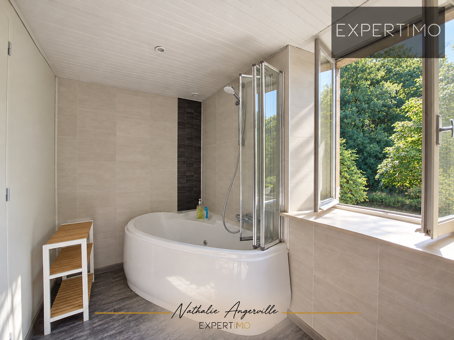 Salle de bain du moulin réhabilité Salle de bain moderne avec baignoire et douche, fenêtres donnant sur la nature.