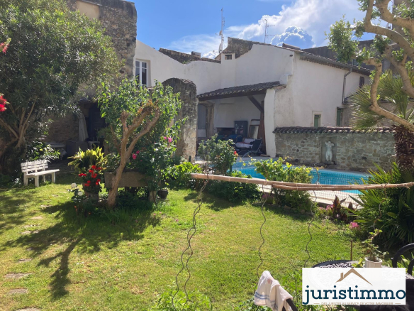 Jardin d'une propriété avec piscine et deux habitations au pied du château de Mondragon.