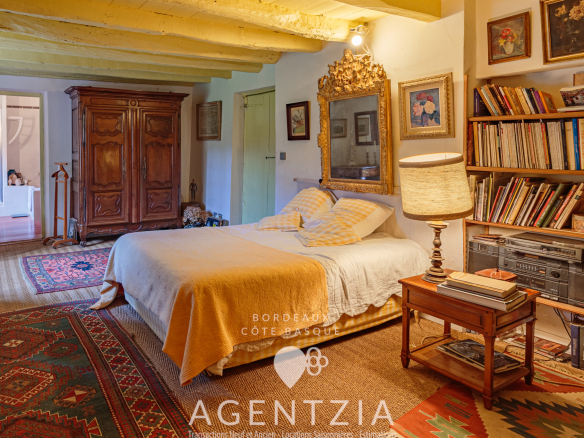 Bedroom in a Labourdine house with bed, wooden furniture and vintage decoration.