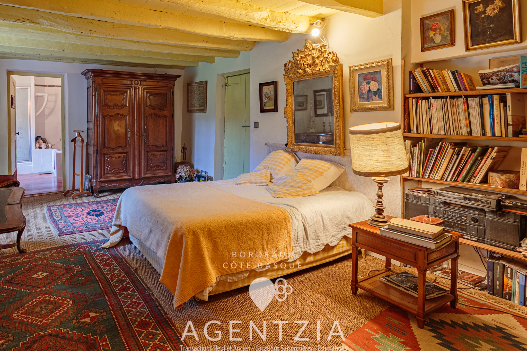 Bedroom in a Labourdine house with bed, wooden furniture and vintage decoration.