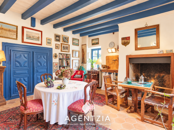 Interior of a Labourdine house in Cambo-les-Bains, with a dining table and a sitting area.
