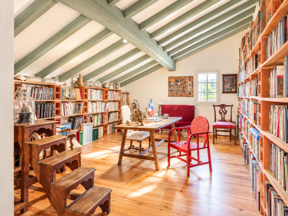 Interior of a Labourdine house with shelves full of books and wooden furniture.