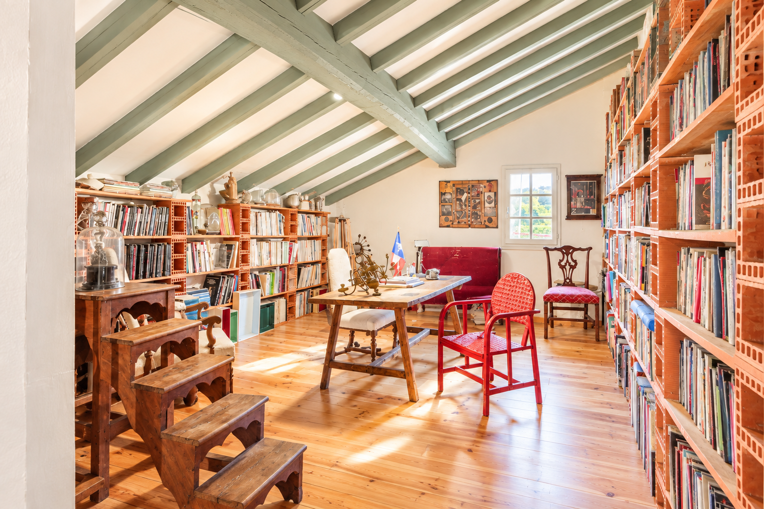 Interior of a Labourdine house with shelves full of books and wooden furniture.