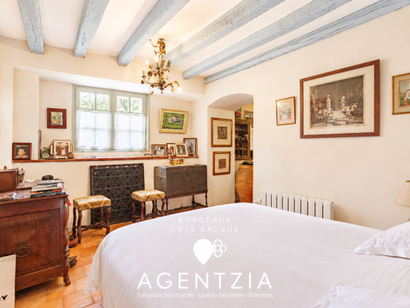 Room in a Labourdine house in Cambo-les-Bains, with light walls and wooden beams.
