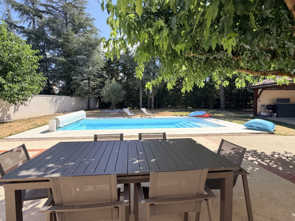Terrace with table and chairs, swimming pool and sun loungers in Saint-Just-Saint-Rambert.