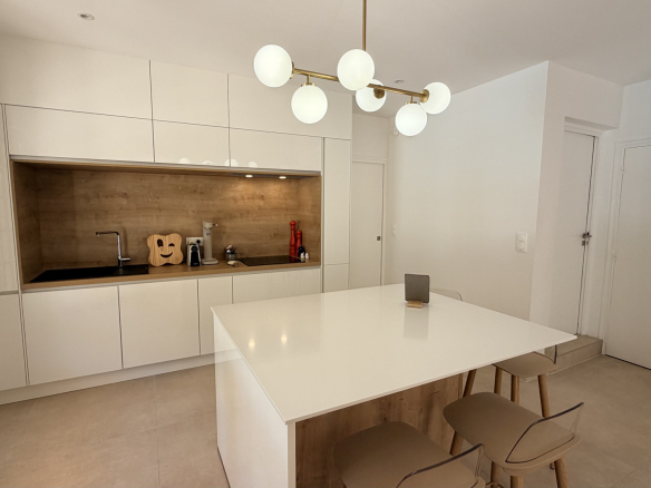 Modern and bright kitchen with a central island and white furniture.