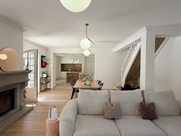 Interior of a renovated house with living room, fireplace and dining room.