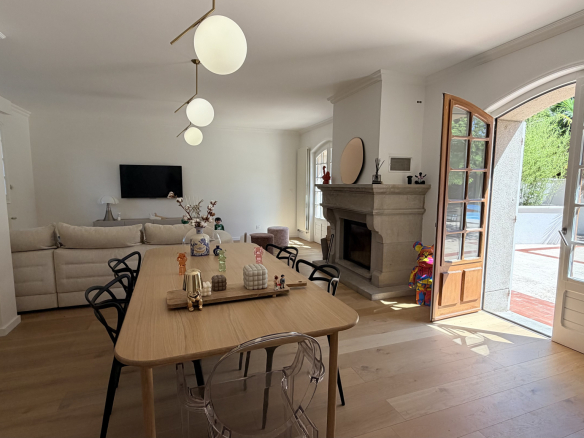 Interior of a renovated house with living room, fireplace and dining room in Saint-Just-Saint-Rambert.