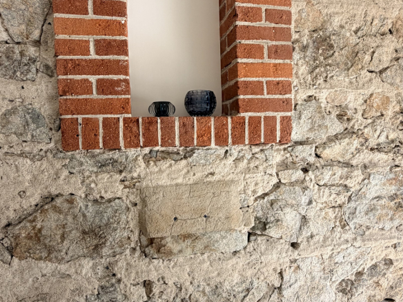 Stone wall with a brick niche, interior of a renovated house.