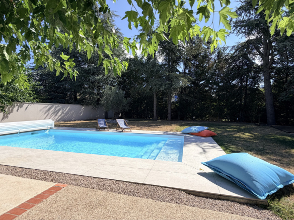 Swimming pool with sun loungers and garden in a house in Saint-Just-Saint-Rambert.
