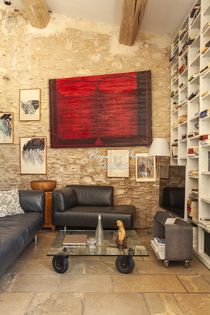 Living room of a stone house in Villars Interior of a stone house with a modern living room, stone walls and artwork.