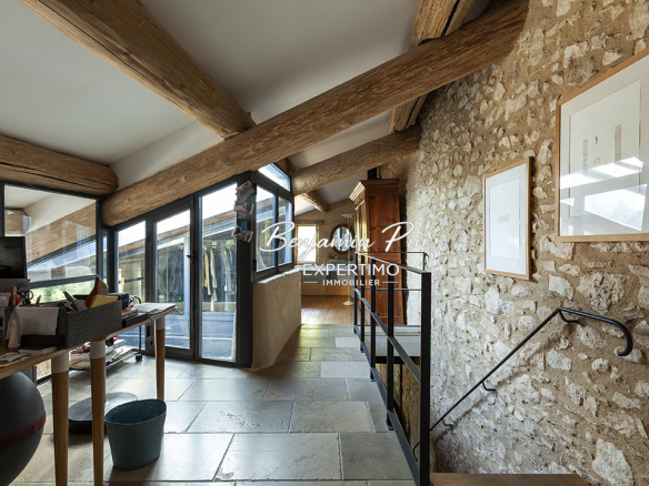 Interior of a renovated stone house, with exposed beams and workspace.