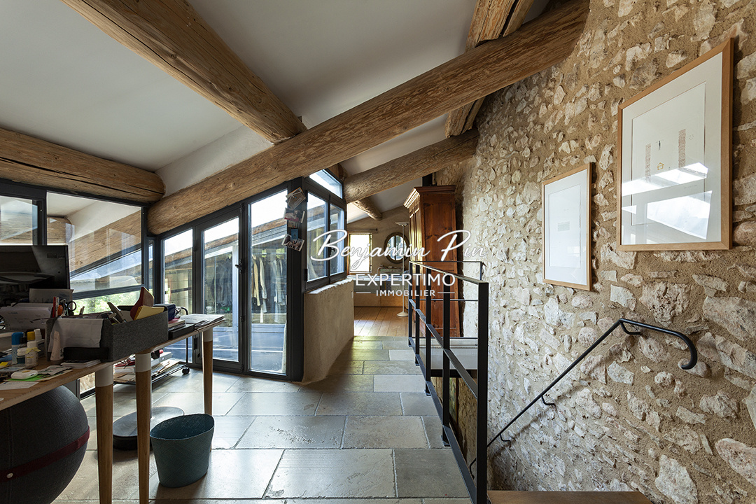 Interior of a house in Villars Interior of a renovated stone house, with exposed beams and workspace.