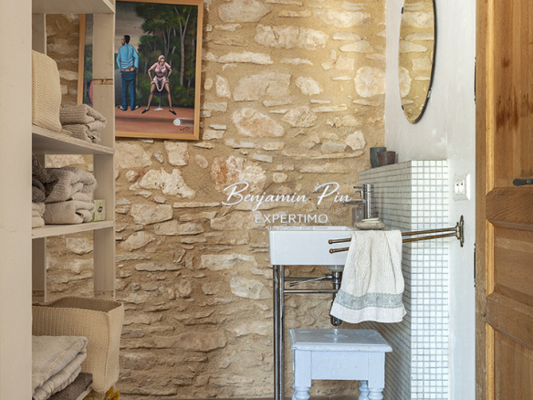 Interior of a renovated stone house with towels and a mirror.