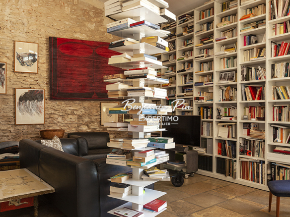 Interior of a house in Villars with a modern library and stone walls.