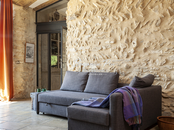 Interior of a renovated stone house with a sofa in a bright living room.