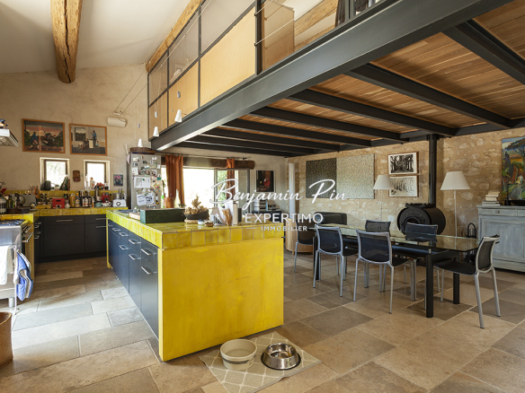 Interior of a renovated stone house with a modern kitchen and dining area.
