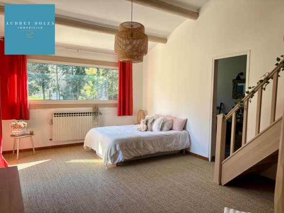 Bright room with bed, simple decor and staircase, in Salon-de-Provence.