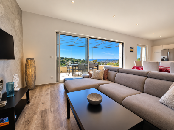 Intérieur d'une maison moderne avec vue sur le Luberon, salon lumineux et terrasse.
