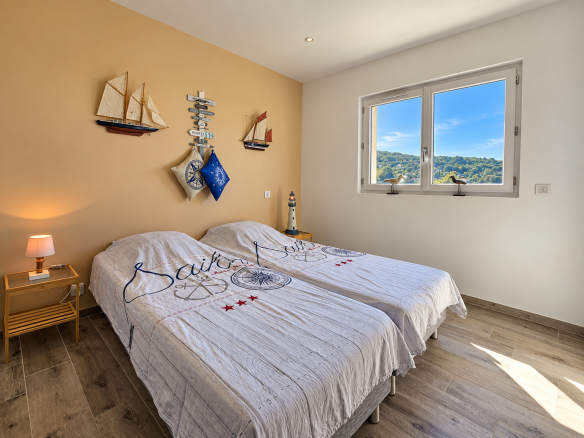 Chambre d'une maison récente à Apt avec deux lits jumeaux et vue sur le Luberon.