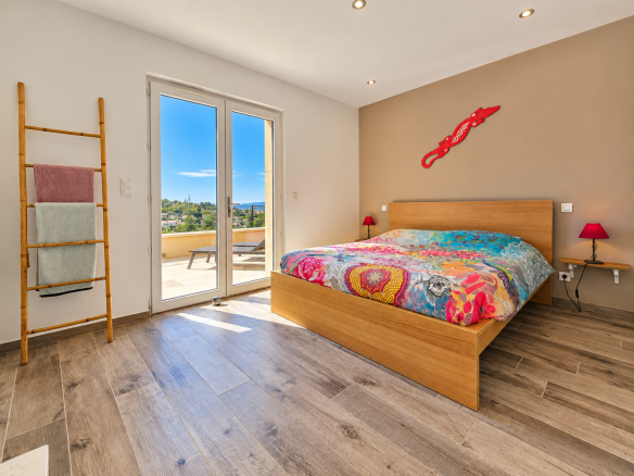 Chambre d'une maison récente à Apt, avec lit double et accès à un balcon.