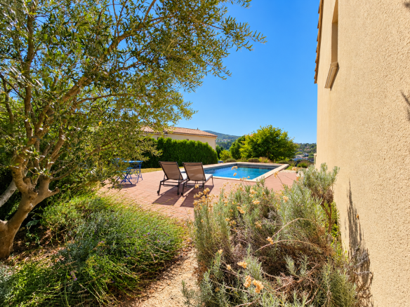Vue d'une maison récente avec piscine et jardin, entourée de végétation à Apt, Luberon.