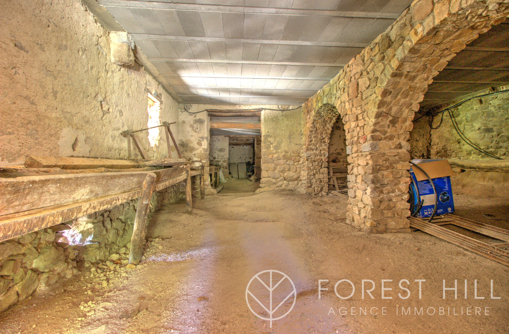 Intérieur d’un mas en pierre Intérieur d'un mas en pierre avec des murs en pierre apparente et un sol en terre battue.