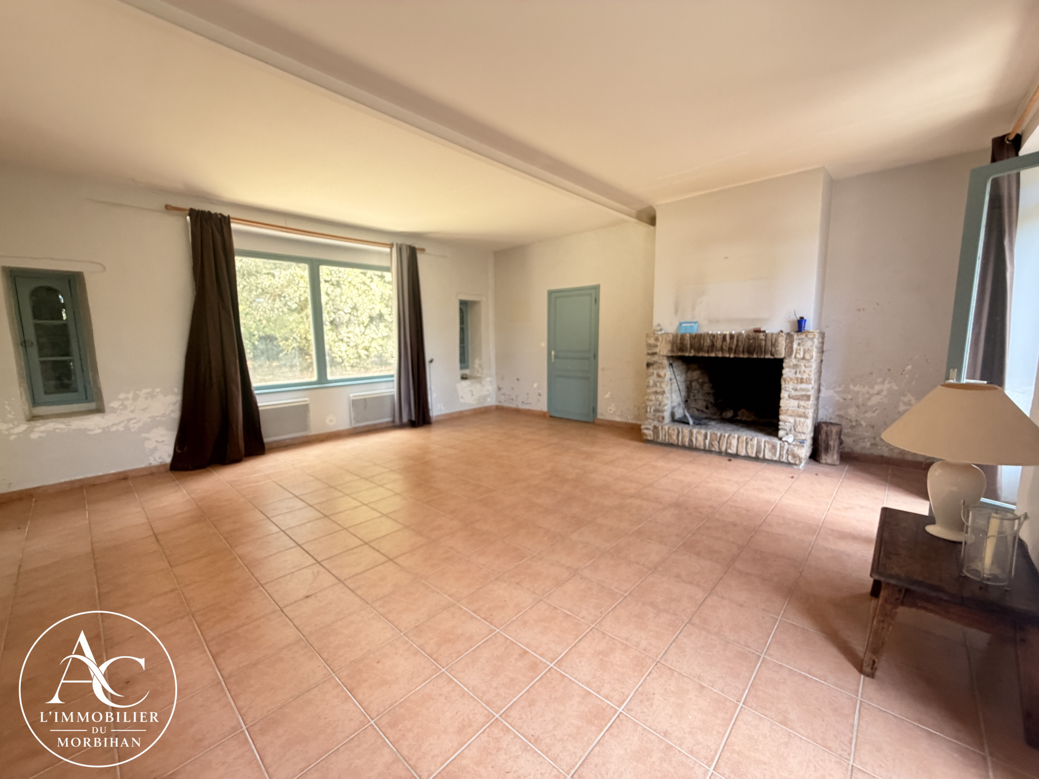 Living room of a longhouse in Sarzeau Interior of a farmhouse with a bright living room and a large fireplace.