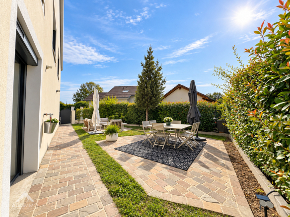 Jardin d'une maison rénovée avec mobilier de jardin à Saint-Genis-Pouilly.