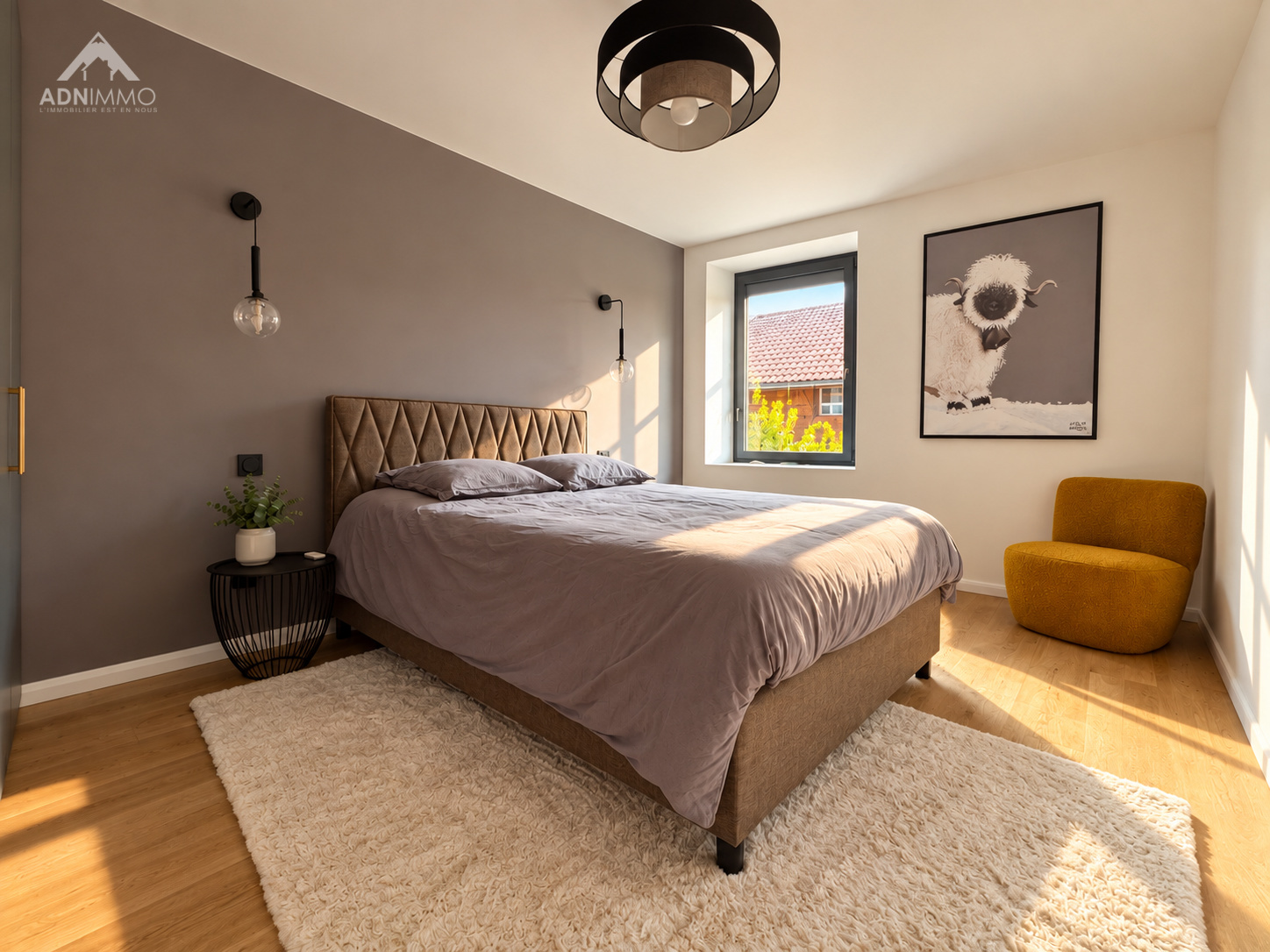 Chambre moderne dans une maison rénovée Chambre spacieuse avec lit double, mur gris et décoration moderne, lumineuse, dans une maison rénovée.