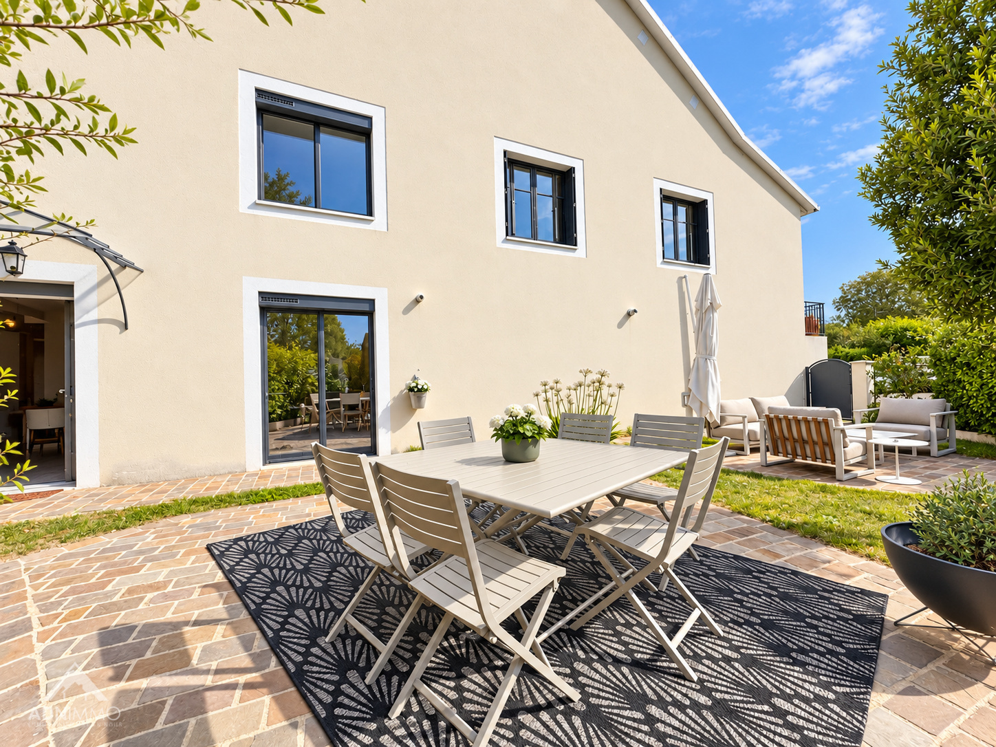 Terrasse d’une maison rénovée à Saint-Genis-Pouilly Terrasse d'une maison rénovée avec table et chaises, entourée de verdure à Saint-Genis-Pouilly.