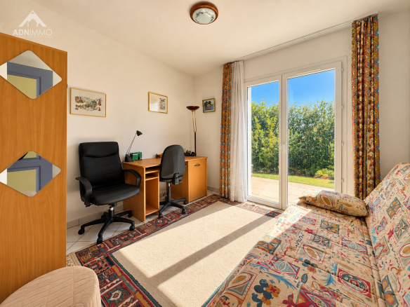 Chambre lumineuse avec bureau et accès à l'extérieur dans une maison à Saint-Jean-de-Gonville.