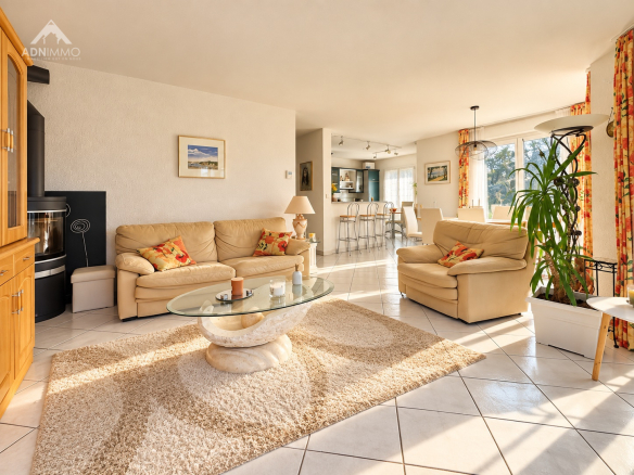 Intérieur d'une maison spacieuse avec salon lumineux et mobilier confortable.