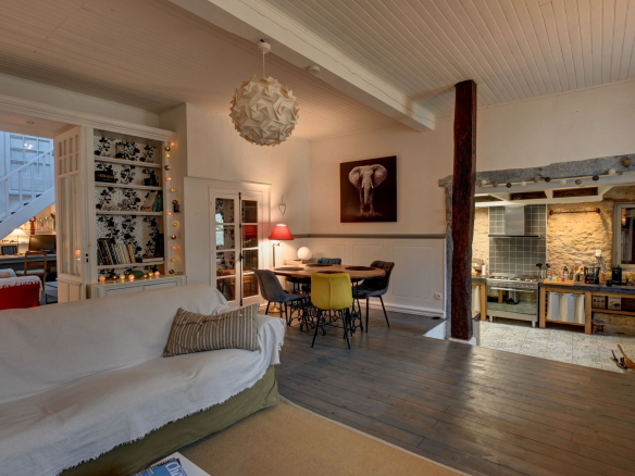Interior of a stone house with living room, dining room and open kitchen.