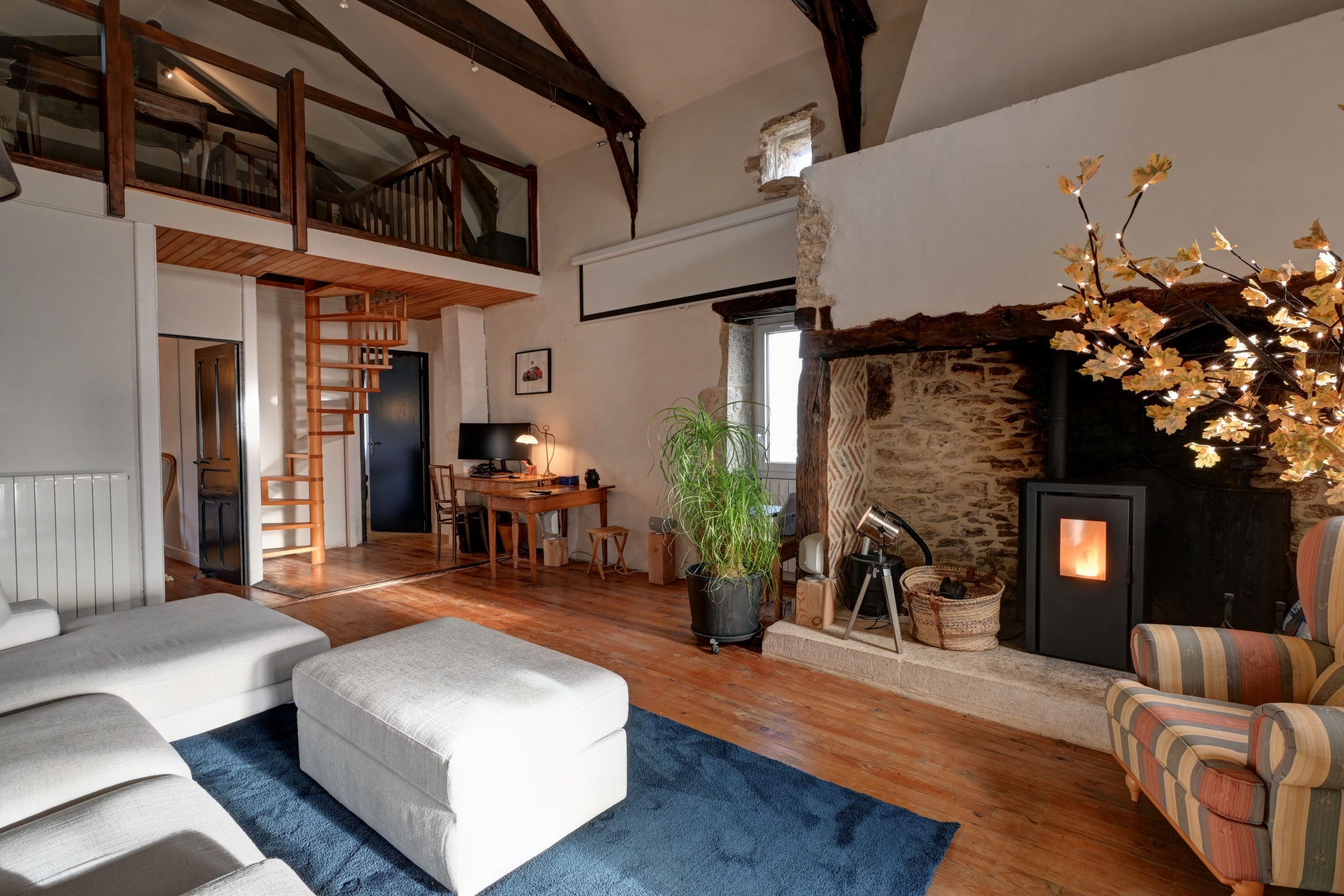 Interior of a stone house in Tournon-d'Agenais Interior of a stone house with living room, office and wood-burning stove.